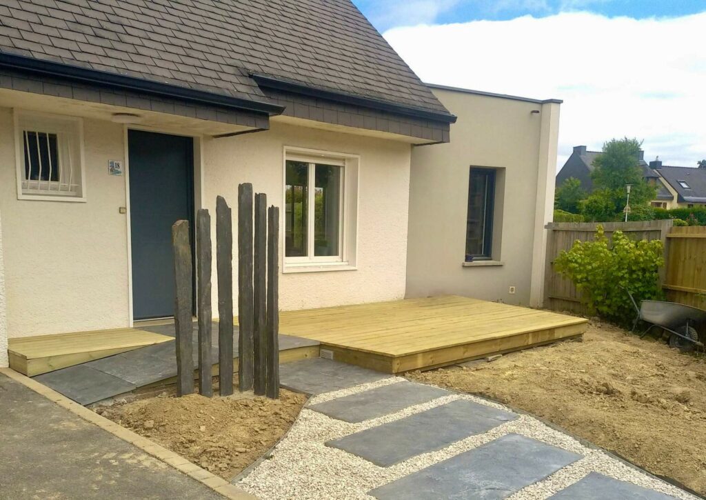 Rénovation en cours d’une entrée de maison avec allée en palis ardoise et terrasse en pin à Montgermont près de Rennes