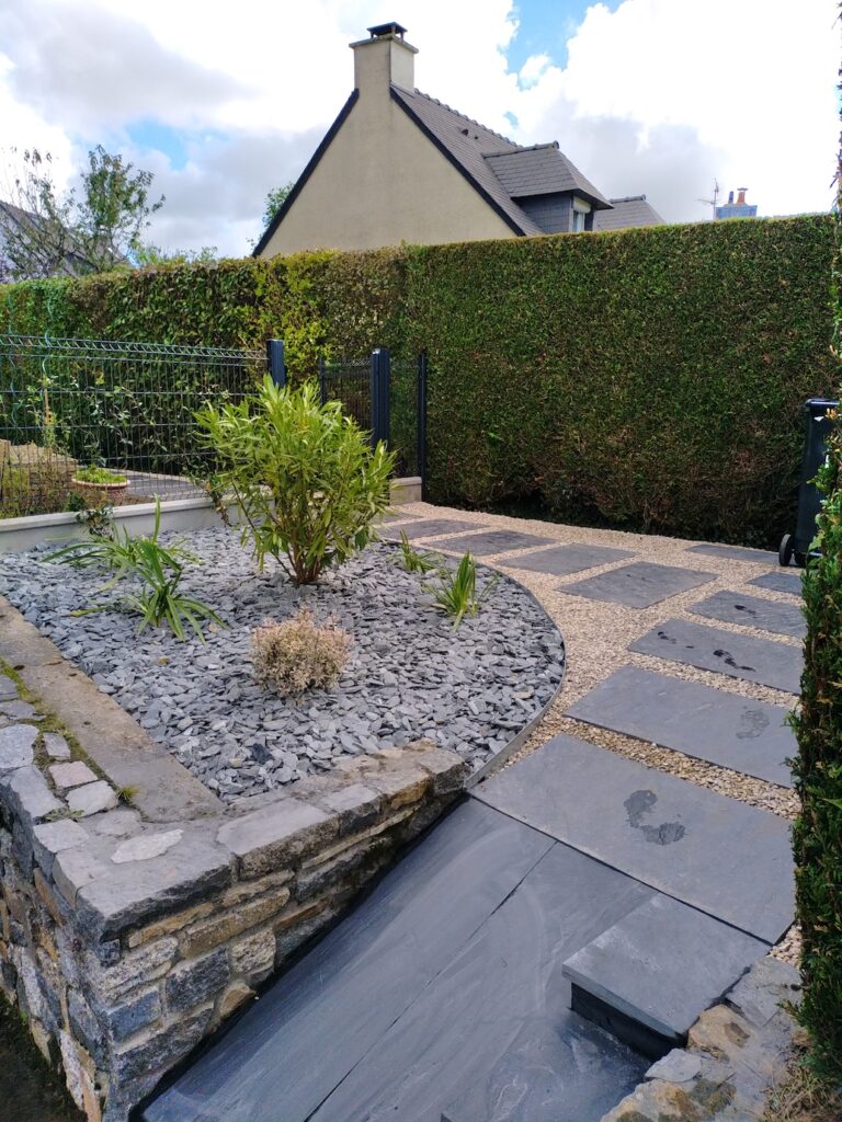 Accès paysager avec dalles en schiste, gravier décoratif et massif minéral à La Chapelle-des-Fougeretz