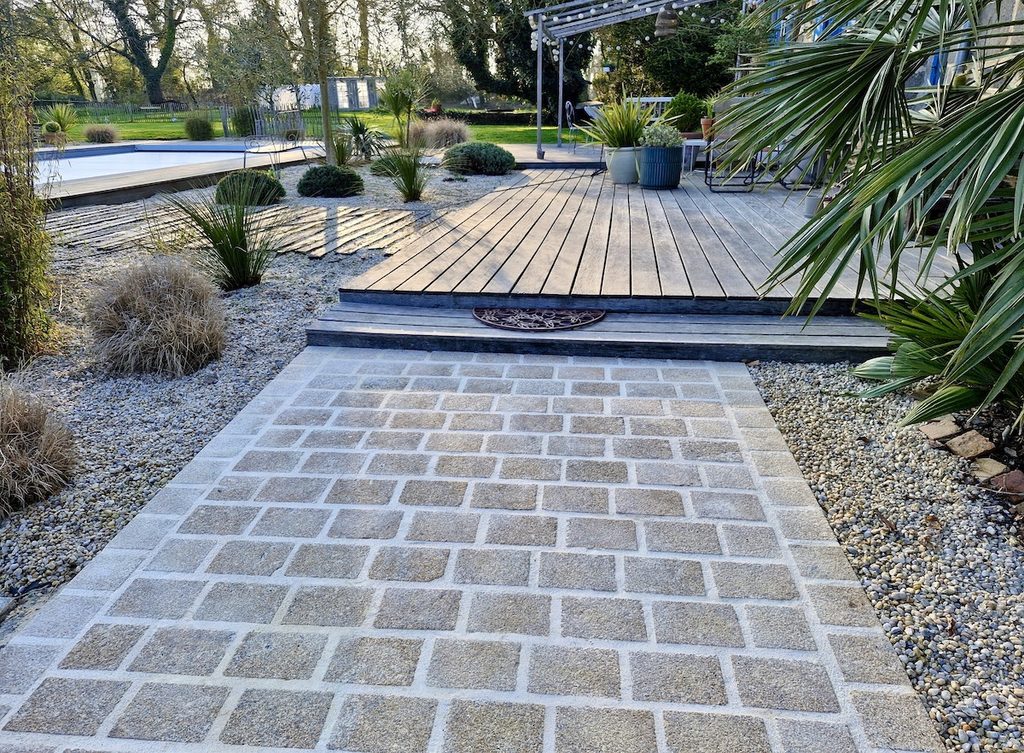 Accès en pavage granit à la propriété en parfaite harmonie avec le jardin, la piscine et l'habitation