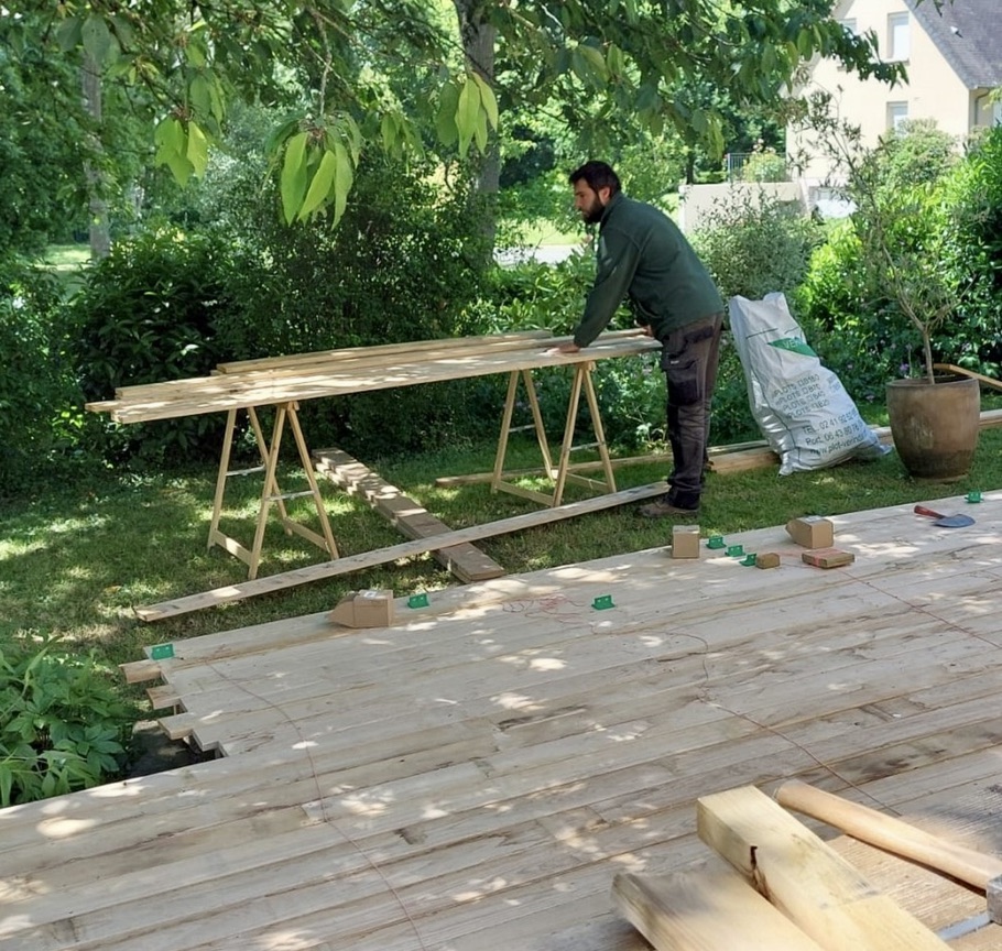 Nos réalisations 1 Paysagiste d'Authentik Paysages en train de réaliser une terrasse en bois de châtaignier